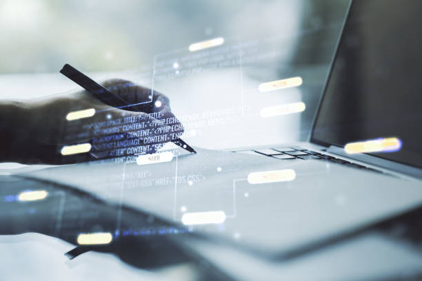 istock Multi exposure of abstract software development hologram and hand writing in notebook on background with laptop, research and analytics concept 2151671895