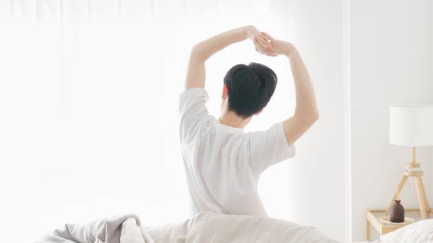 a man wakes up and stretches - リフレッシュ ストックフォトと画像