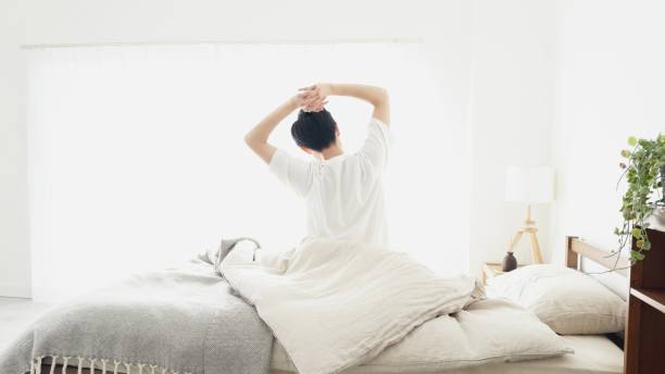 a man wakes up and stretches - 朝起きる ストックフォトと画像