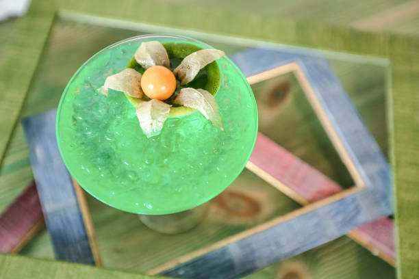 A close up of a green drink placed on a table.