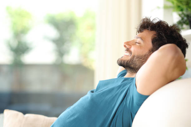 homem bonito feliz descansando e relaxando em casa - confortável - fotografias e filmes do acervo