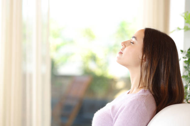 istock Woman at home breathing sitting on a couch 2151674757