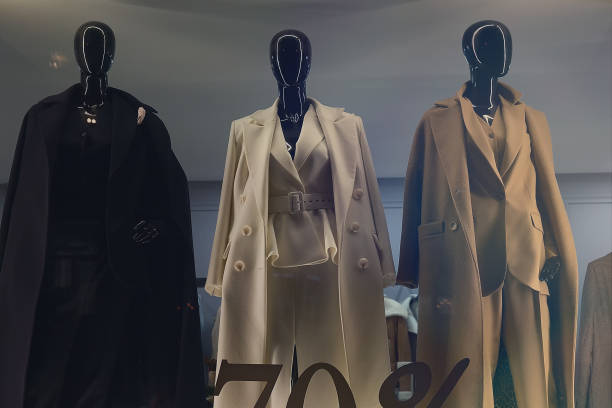 istock Female mannequins in elegant coats in a store window 2151676458