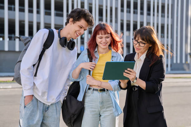 istock Woman agent teacher social worker working with college students using digital tablet outdoor 2151678124