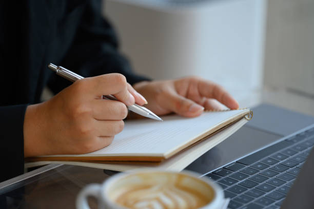 istock Close up businessman taking notes and using laptop at workplace 2151678381