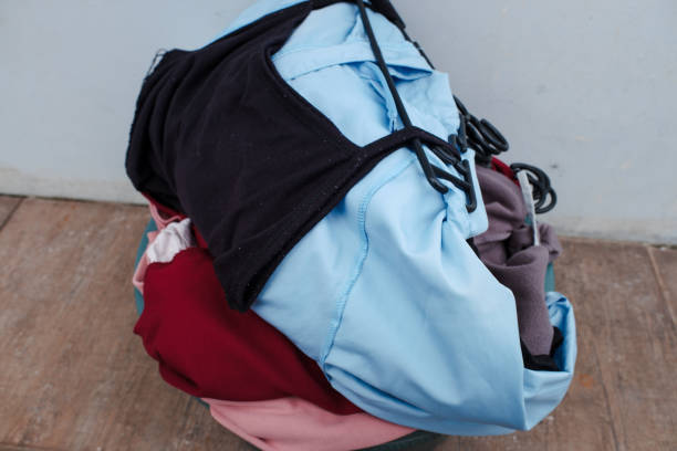 istock Clothes in a laundry wooden basket on floor 2151678494