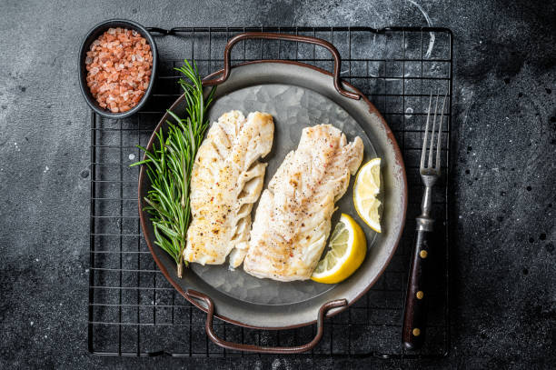 istock Roast Fillets of codfish, cooked cod fish meat. Black background. Top view 2151678560