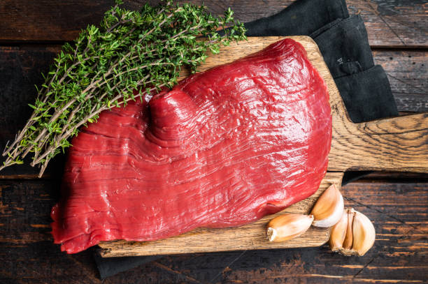 istock Alternative flank beef steak, raw meat. Wooden background. Top view 2151678666