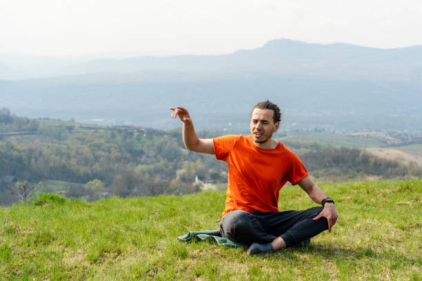 Man sitting on the mountain peak and telling something