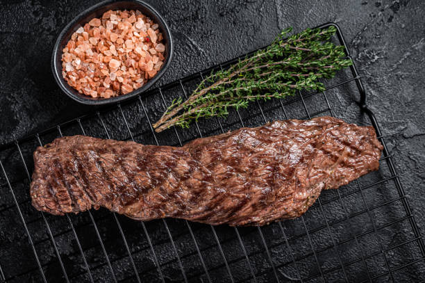 istock Grilled meat steak Machete skirt on a rack. Black background. Top view 2151680171