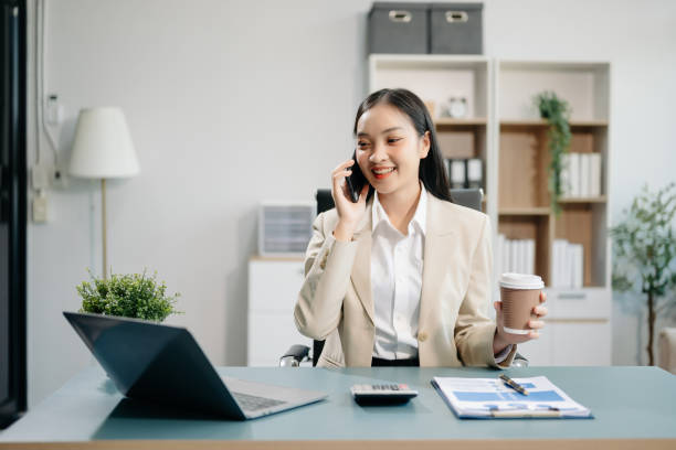 istock Asian woman using laptop and tablet while sitting at her working place. Concentrated at work. 2151680275
