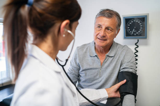 istock Senior Man Getting Blood Pressure Checked by Doctor 2151681725