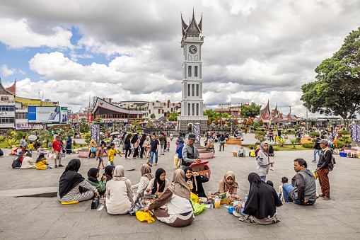 Bukittinggi, West Sumatra, Indonesia - February 4th 2024: The famous clock tower on the central square in the center of the city is the centrum for the everyday life in the main city in this part of Sumatra