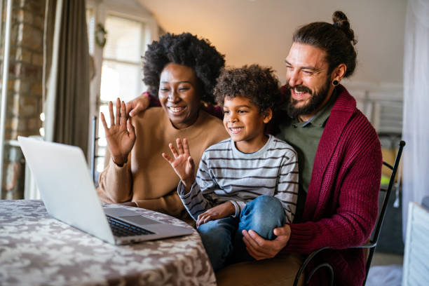 istock Happy multiethnic diverse family gathering around notebook and having fun during a video call 2151684404