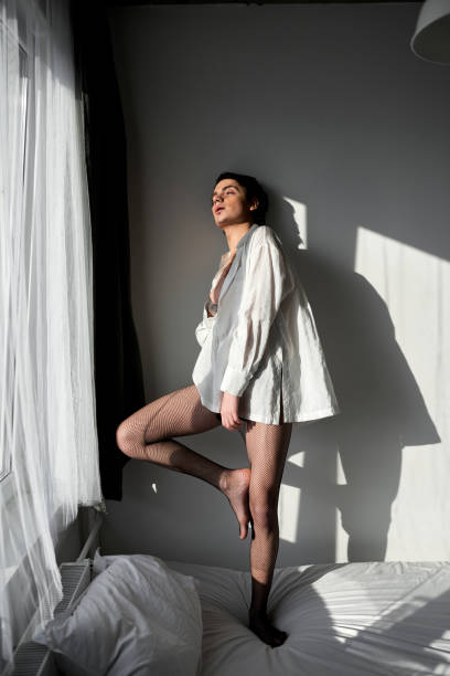 istock Sexy relaxed careless handsome man standing on bed 2151684756
