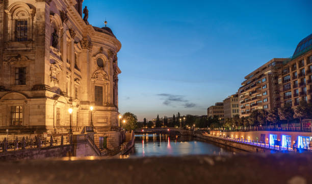 view from bridge over spree river in central berlin at blue hour with cathedral in the foreground
