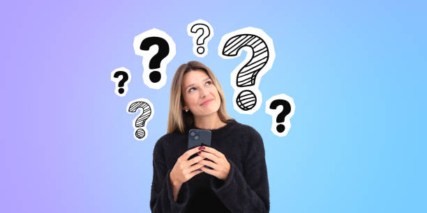 istock Pensive young woman smiling using smartphone looking up at question marks 2151688168