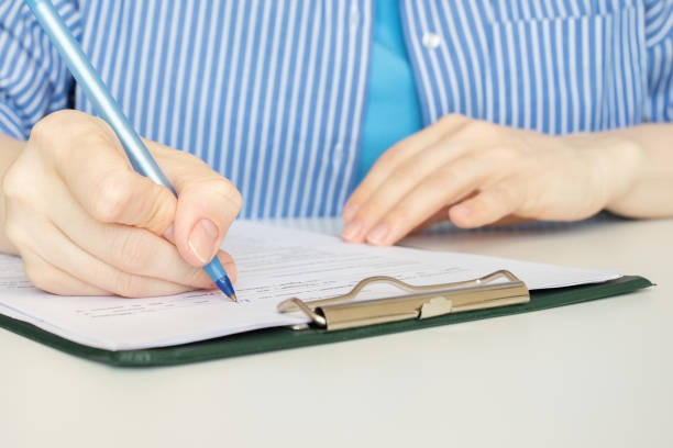 istock fill out documents, a woman writes on forms, employment contract, HR manager, insurance paperwork, client service 2151692691