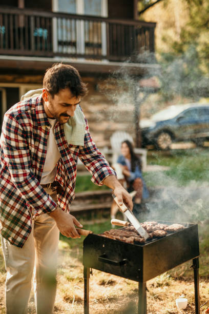 istock Handsome male preparing barbecue outdoors for friends 2151693050
