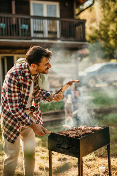 istock Handsome male preparing barbecue outdoors for friends 2151693054