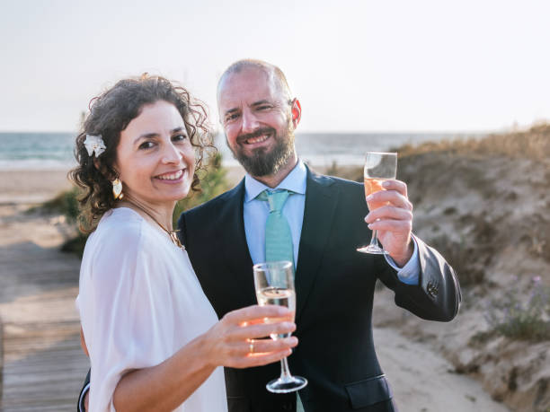 istock Joyful Newlyweds Celebrating on Beach at Sunset 2151693994