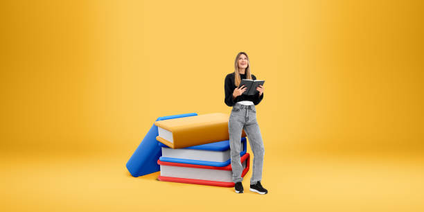 istock Woman with notebook standing near cartoon books, empty copy space background 2151696398