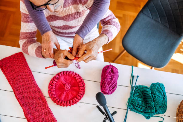 istock Old couple hands showing knitting process going live on internet from home 2151696549