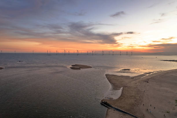 Wind turbine clusters along the coastline at dusk