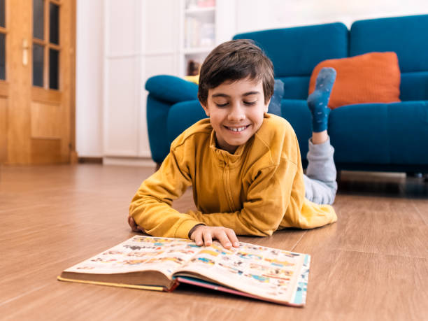istock Young Child Engrossed in Reading a Colorful Book on Floor 2151697690