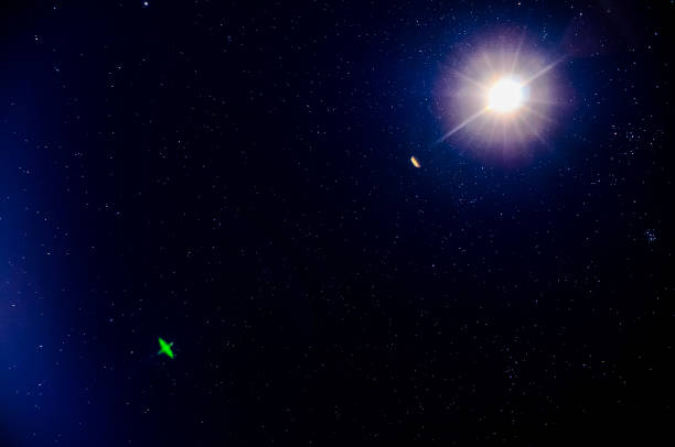 A dark sky with a bright star in the center. The star is surrounded by a greenish glow, real image