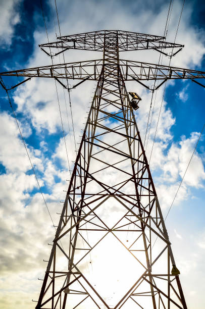 istock A tall power tower with a man on top of it 2151700572