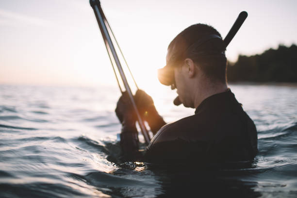 istock Side view of man preparing speargun for fish hunting 2151701219