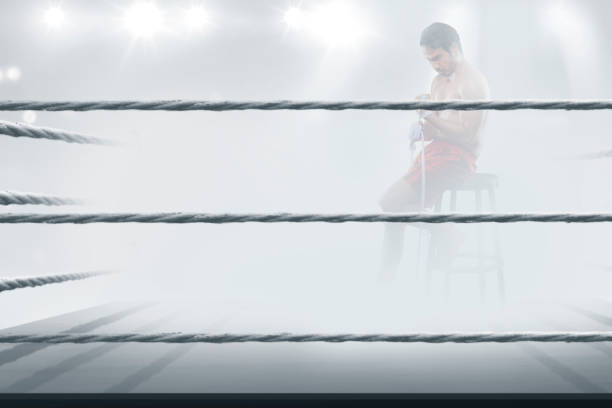 A boxer inside the ring with mist ready to fight for training session. An athlete doing train in the boxing arena for a championship.