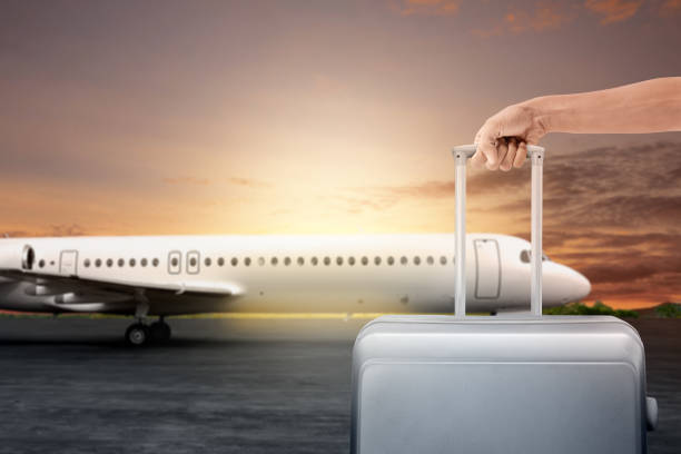 istock Human hand holding a suitcase for traveling on the runway 2151707233