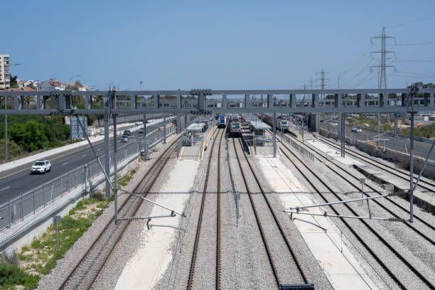 Train stopped at Herzliya train station, with the Ayallon highway on the side, elevated view.