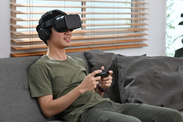 istock Young man playing video game with joystick on virtual reality headset, entertainment, futuristic technology concept. 2151718563