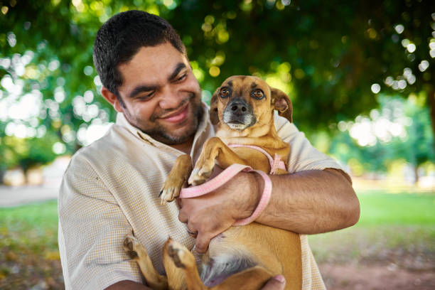 istock Latin man and his dog in a park 2151720541