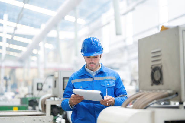 istock A male engineer from Europe is responsible for controlling work and machinery, holding a laptop and radio within the plastic and steel industry for export to the global market. 2151723996
