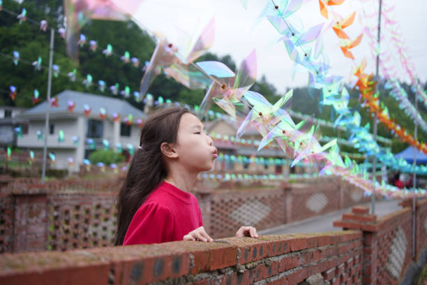 little girl blowing windmill