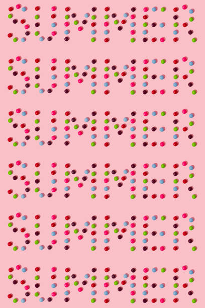 Creative pattern made of multicolored candies on a pink background. Summer concept.