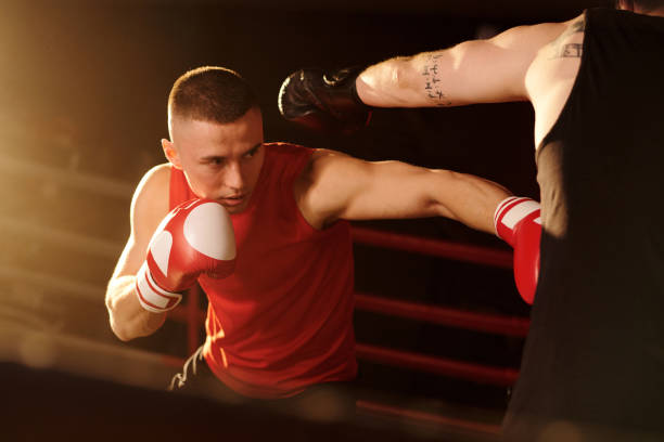 istock Young boxer in sportswear hitting rival 2151726560