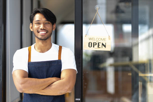 istock A young man a small start-up business entrepreneur who started a small restaurant. A waiter waits for a customer at the door of a coffee shop. 2151726860