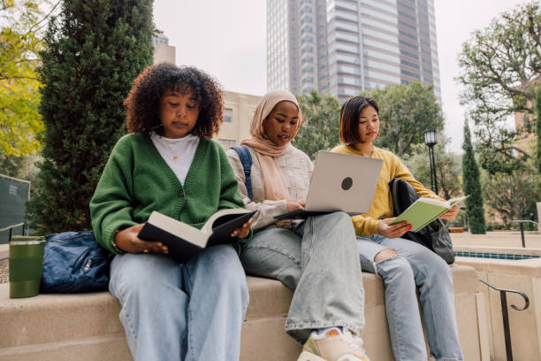 istock Three teenage student friends studying outdoors in the University campus 2151731284