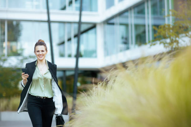 istock smiling modern female worker near office building walking 2151733159