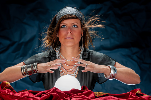 Fortune teller with Cristal ball on red velvet. Looking up.