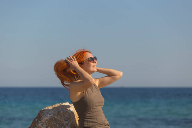 Beautiful woman in long dress enjoy sunset sunlight at sea