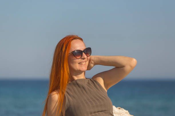 Beautiful woman in long dress enjoy sunset sunlight at sea