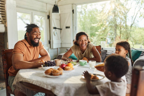 istock Happy black family talking during breakfast at dining table. 2151740298