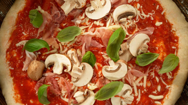 Freeze motion of falling various ingredients on pizza dough with sugo, top down view