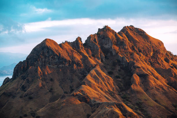 Stunning landscape view of golden sunrise on the rugged peaks of Padar Island in the Komodo Islands, Flores, Indonesia. A breathtaking natural scene.
